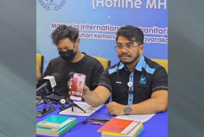 Hishamuddin menunjukkan video tular memaparkan Danish (kiri) dalam keadaan tidak berpakaian dalam sidang akhbar MHO di Kuala Lumpur pada Rabu.