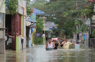 Antara mangsa dibawa ke tempat selamat selepas kawasan di Manila dilanda Taufan Uwan. Foto AFP