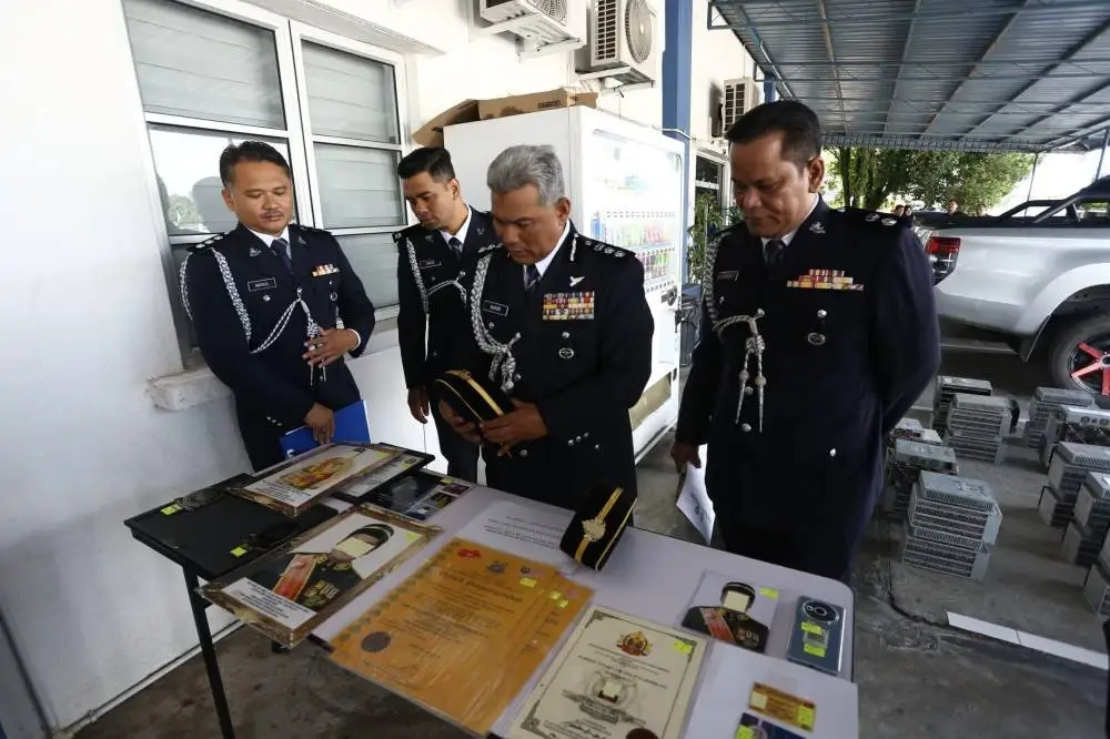 Bakri (dua dari kanan) menunjukkan rampasan termasuk beberapa dokumen ‘Watikah Penganugerahan’, sijil, lambang, kad keahlian pertubuhan tidak sah serta gambar suspek memakai pakaian istiadat dengan pelbagai gelaran kehormatan palsu.