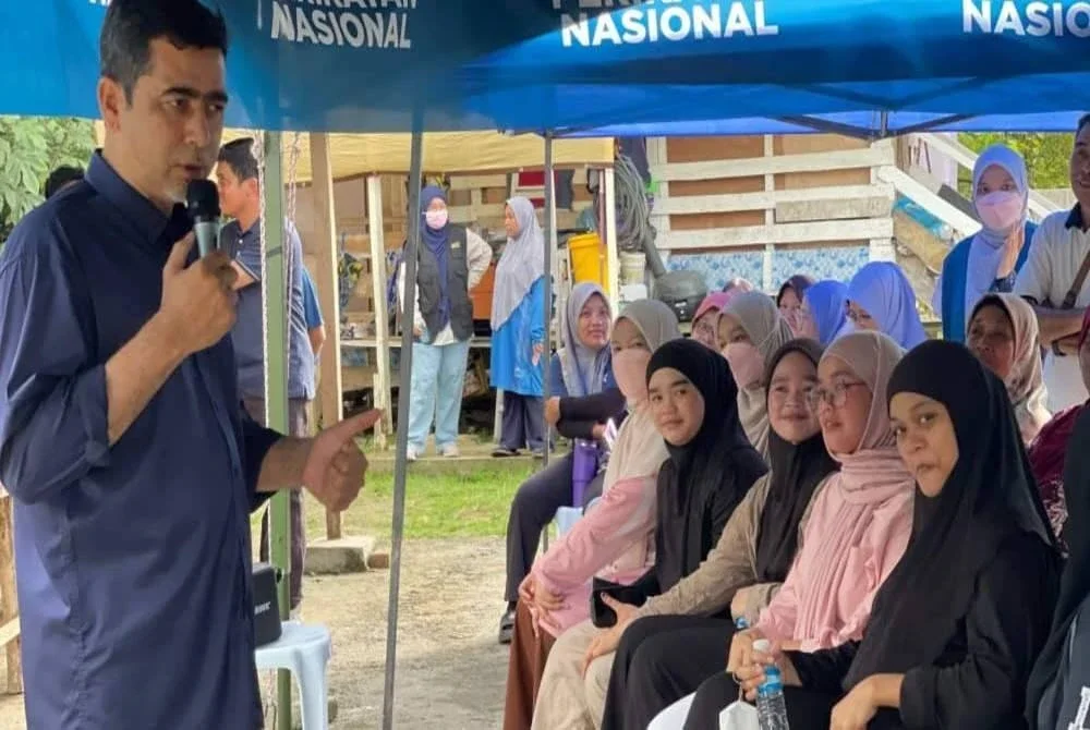 Aliakbar (kiri) semasa berkempen di kawasan DUN Karambunai yang ditandinginya.