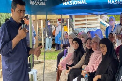 Aliakbar (kiri) semasa berkempen di kawasan DUN Karambunai yang ditandinginya.