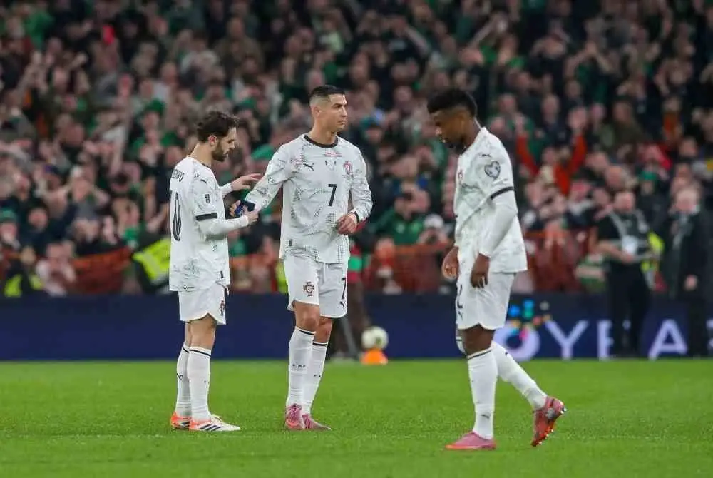 Ronaldo menyerahkan lilitan kapten kepada Bernardo Silva (kiri) selepas dia dilayangkan kad merah. Foto: AFP
