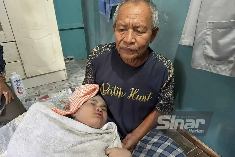Amni Nazirah (kiri) yang tidur di pangkuan Che Idris (kanan). FOTO SINAR HARIAN – ADILA SHARINNI WAHID