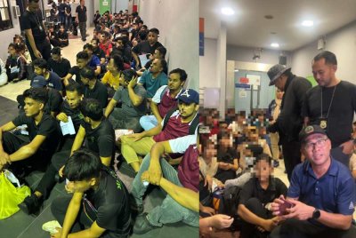 Khairrul Aminus (duduk, kanan) ketika memeriksa warga asing yang ditahan dalam operasi penguatkuasaan JIM di Pelangi Damansara, Petaling Jaya di sini malam tadi.