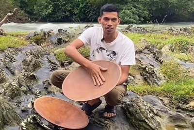 Mohamad Hafizudin menunjukkan dulang emas kayu merbau yang dijualnya.