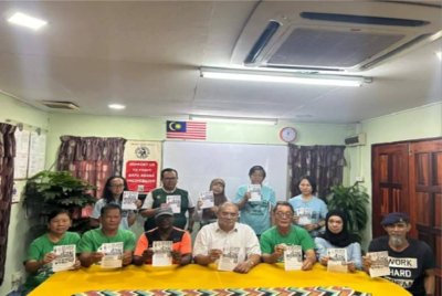 Abdul Hanan (duduk tengah) bersama wakil-wakil penduduk memegang risalah perhimpunan aman yang dijadualkan pada Isnin depan.
