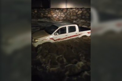 Sebuah kenderaan pacuan empat roda dihanyutkan air banjir di sekitar Makkah. - Agensi