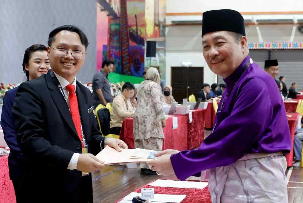 Hajiji (kanan) mengemukakan borang pencalonan pada proses penamaan calon PRN Sabah ke-17 DUN N12 Sulaman di Dewan Seri Sulaman pada Sabtu. Foto Bernama