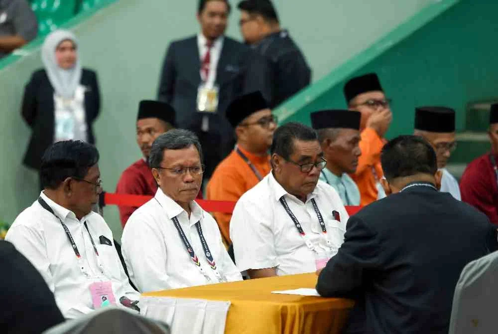 Mohd Shafie (dua, kiri) selesai menyerahkan borang penamaan calon kepada SPR pada 9.22 pagi Sabtu di Dewan Arena Masyarakat Semporna. Foto Bernama