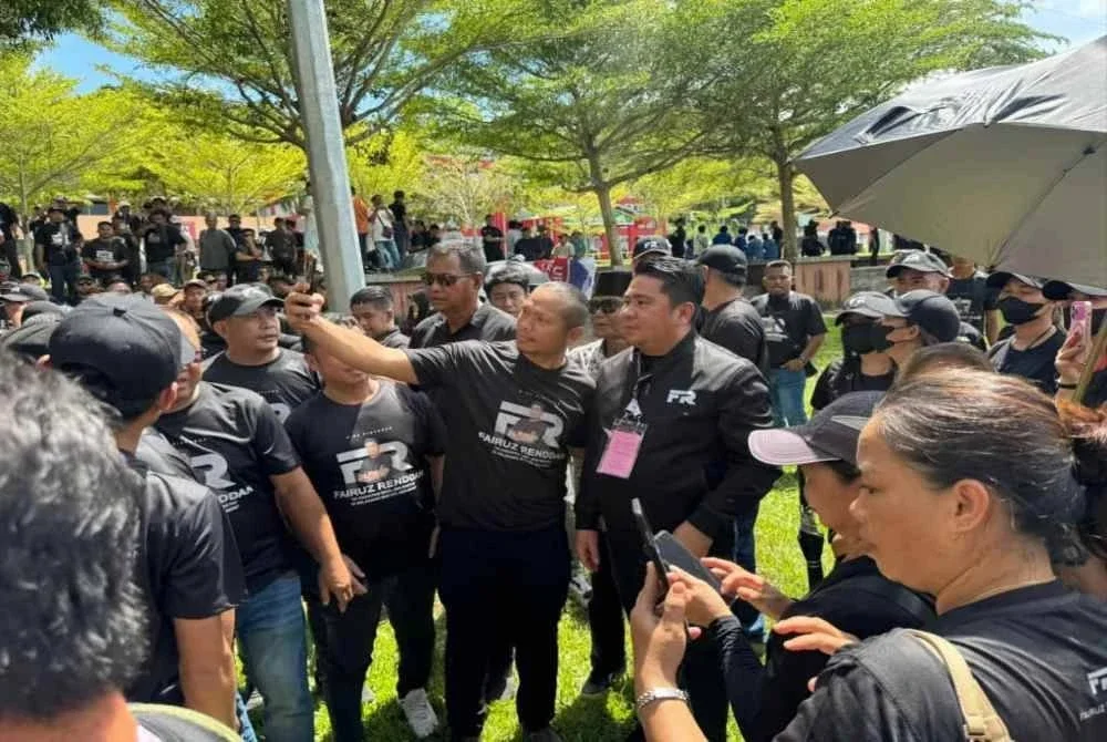 Fairuz (tengah) berswafoto bersama salah seorang penyokongnya di pusat penamaan pencalonan di Dewan Tun Said Keruak, Kota Belud pada Sabtu. - Foto: FB Fairuz Renddan 