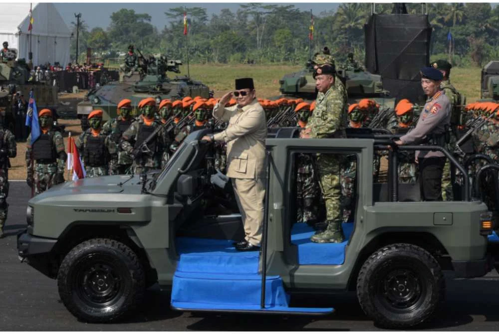 Prabowo Subianto ketika memeriksa barisan anggota tentera dari sebuah kenderaan semasa upacara Operasi Pasukan dan Penghormatan Ketenteraan di Lapangan Udara Suparlan, Bandung, Jawa Barat pada 10 Ogos 2025. - Foto: AFP