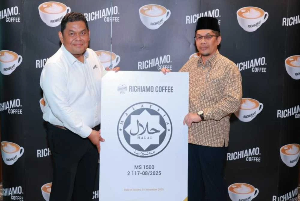 Muhamad Zamry (kiri) pada majlis penyerahan pensijilan halal daripada Pengarah Bahagian Pengurusan Halal Jakim.