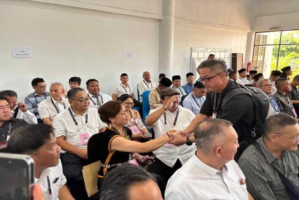 Shone bersalam dengan Edna Jessica ketika bertemu di pusat penamaan calon di Dewan Maksak Likas, Kota Kinabalu pada Sabtu. 