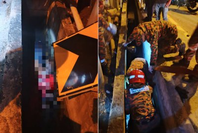 Anggota bomba mengangkat mangsa yang tercampak di dalam longkang.