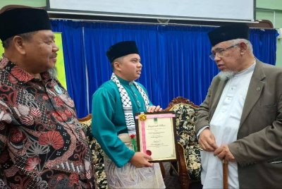 Muhammad Azmi (kanan) bersama penerima Tokoh Sukarelawan Ummah Negeri Perak 2025, Muhammad Aqil Danish Razlan, 24, (tengah) sempena Majlis Perhimpunan Sukarelawan Penggerak Ummah dan Humaniti Negeri Perak di Institut Tadbiran Islam Perak (INTIM) di Ipoh pada Sabtu.
