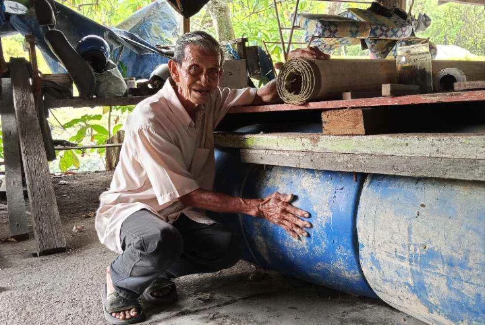 Mohd Alip menunjukkan rakit tong yang dibina sebagai persiapan menghadapi banjir.