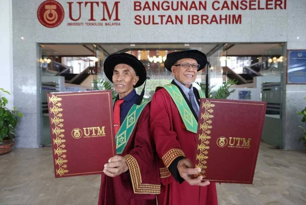Kamarul Azman (kanan) dan Abdul Hakim menunjukkan Ijazah PhD yang diterima pada Majlis Konvokesyen Ke-69 UTM di Johor Bahru pada Ahad.