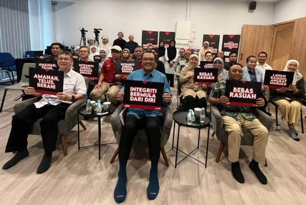 Ahmad Ramdzan (tengah) bersama Badlishah Sham (kiri), Pengarah Bahagian Pendidikan Masyarakat SPRM, Datuk Ahmad Nizam Ismail (kanan) dan tetamu menunjukkan kad Kempen Integriti dan Anti Rasuah 2025 ketika majlis pelancaran KIA 2025 di Conezion IOI Resort City, Putrajaya pada Ahad.