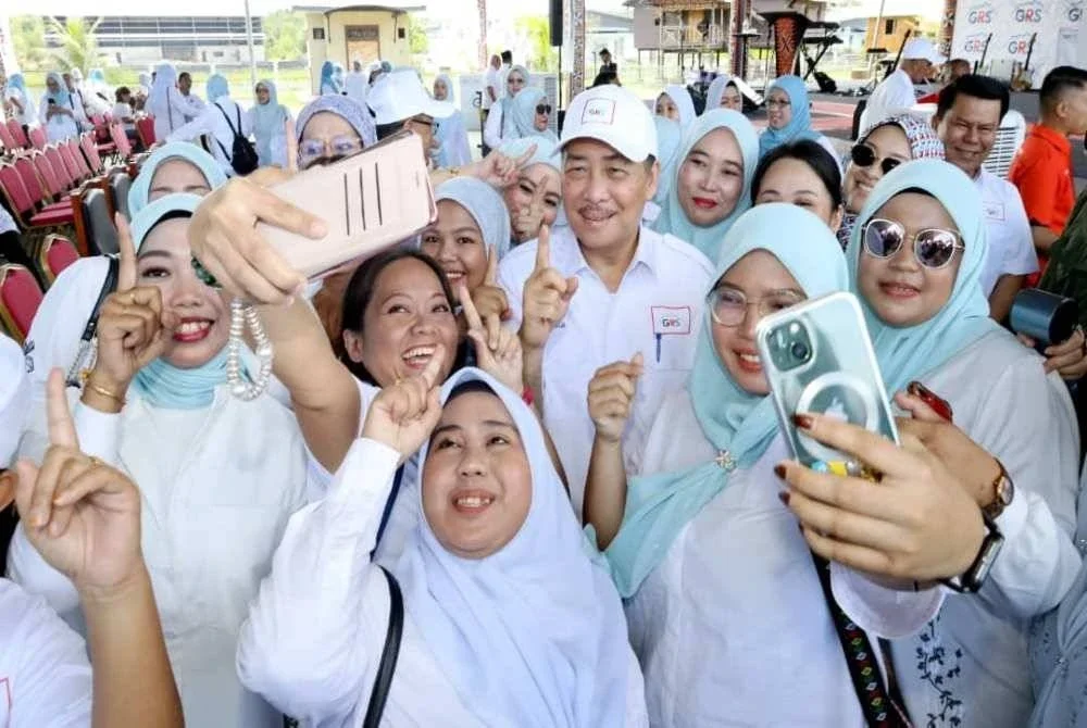 Hajiji merakamkan gambar bersama jentera pilihan raya GRS Sulaman di Dewan Rumpun Bajau Samah di Kampung Lok Batik, Tuaran.