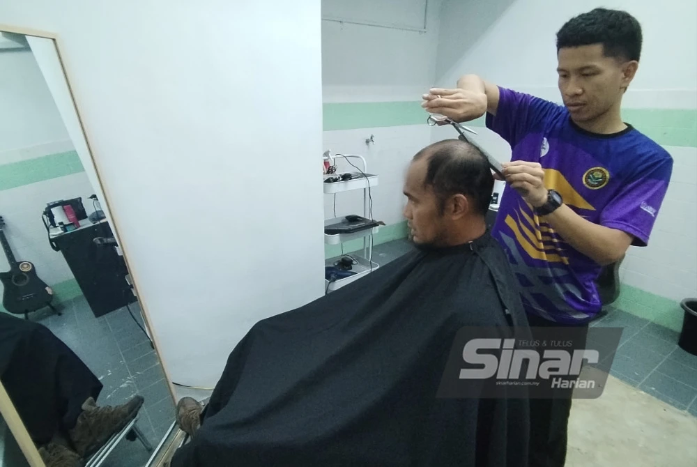 Muhammad Fairul sedia menggunting rambut sebagaimana diingini pelanggan.