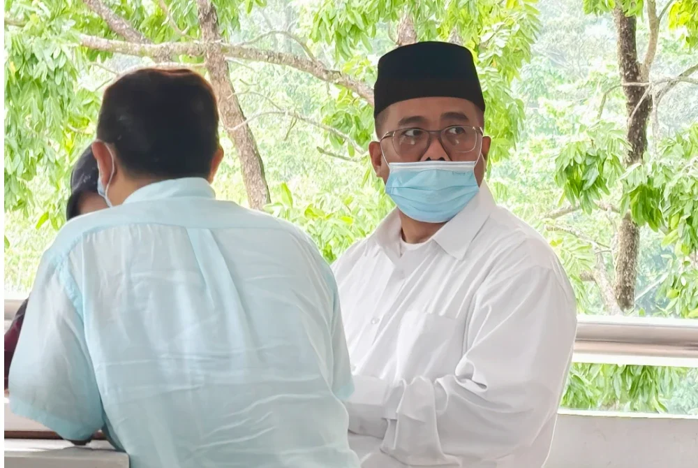 Farid Azhar(kanan) memakai pelitup muka ketika hadir ke mahkamah.