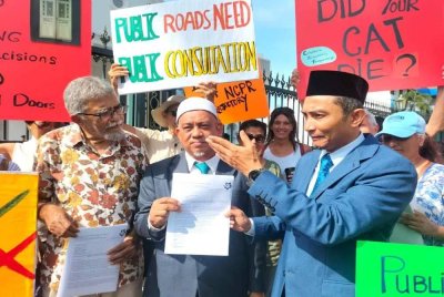 Zulfiqar (kiri) menyerahkan salinan surat kepada Muhammad Fauzi di hadapan bangunan DUN Pulau Pinang pada Isnin.