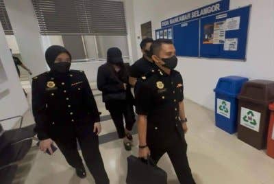 Kah Sing (belakang, dua dari kiri) dibawa ke Mahkamah Sesyen Shah Alam pada Isnin.