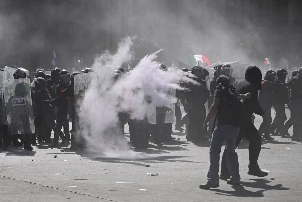 Polis rusuhan Mexico menggunakan perisai untuk melindungi diri semasa demonstrasi menentang kerajaan.