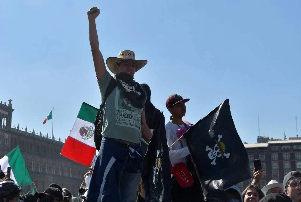 Seorang penunjuk perasaan memegang bendera manga One Piece semasa protes menentang kerajaan Presiden Claudia Sheinbaum di Dataran Zocalo, Mexico City.