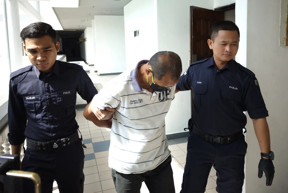 Tertuduh (tengah) mengaku tidak bersalah atas pertuduhan melakukan amang seksual fizikal terhadap seorang pelajar lelaki minggu lalu.