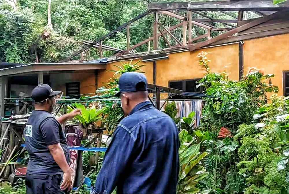 Asmadi meninjau keadaan rumah yang rosak akibat ribut kuat pada minggu lalu.