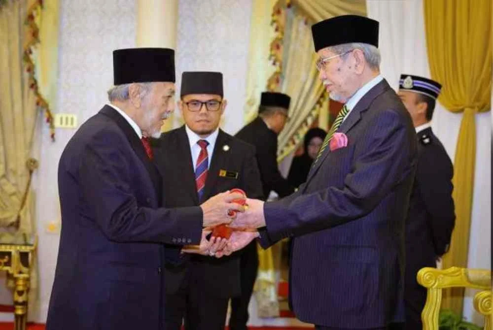 Mohamad Asfia (kiri), menerima surat watikah pelantikan semula sebagai Speaker DUN Sarawak daripada Dr Wan Junaidi, di Astana Negeri, Petra Jaya, pada Selasa. Foto Bernama 