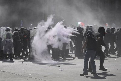 Polis rusuhan Mexico menggunakan perisai untuk melindungi diri semasa demonstrasi menentang kerajaan.