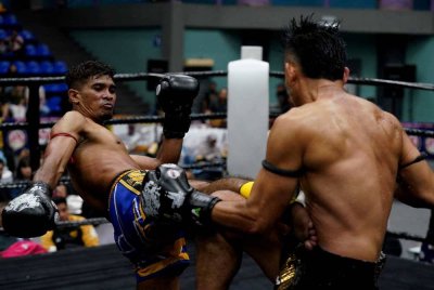 Azri (kiri) melepaskan sepakan padu ke arah Yuskhairul pada pertarungan Grand Final Kuda Merah di Stadium Titiwangsa pada Ahad. Foto Rosli Talib 