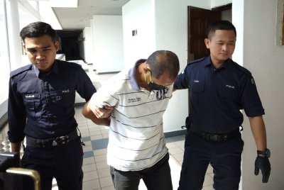 Tertuduh (tengah) mengaku tidak bersalah atas pertuduhan melakukan amang seksual fizikal terhadap seorang pelajar lelaki minggu lalu.