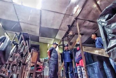 Asmadi melihat keadaan rumah Roslina yang rosak akibat ribut di Bukit Bay Route.