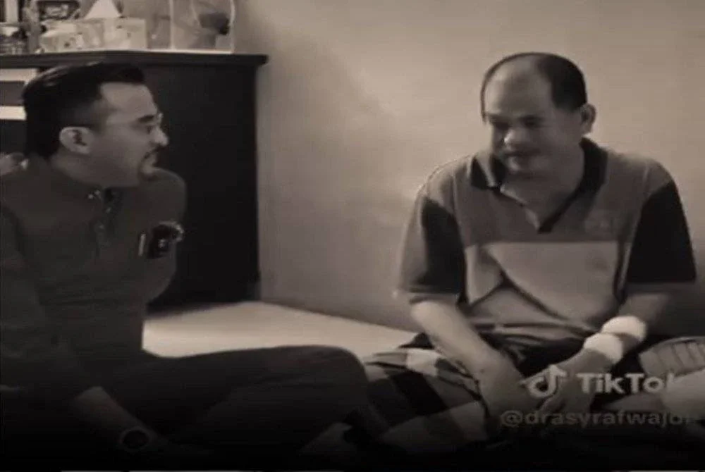 Asyraf Wajdi (kiri) ketika menyantuni bapa Aiman. Foto tangkap layar video dari FB Asyraf Wajdi