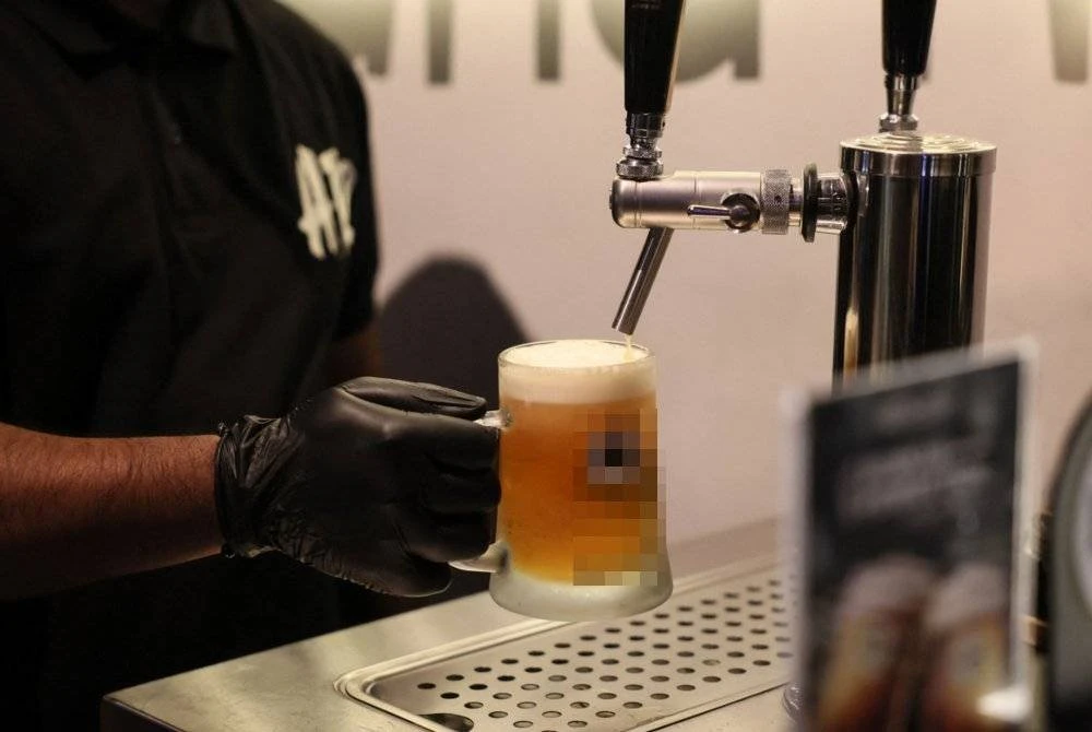 Seorang pelayan bar menyajikan bir tanpa alkohol di kafe A12 di ibu kota Riyadh.