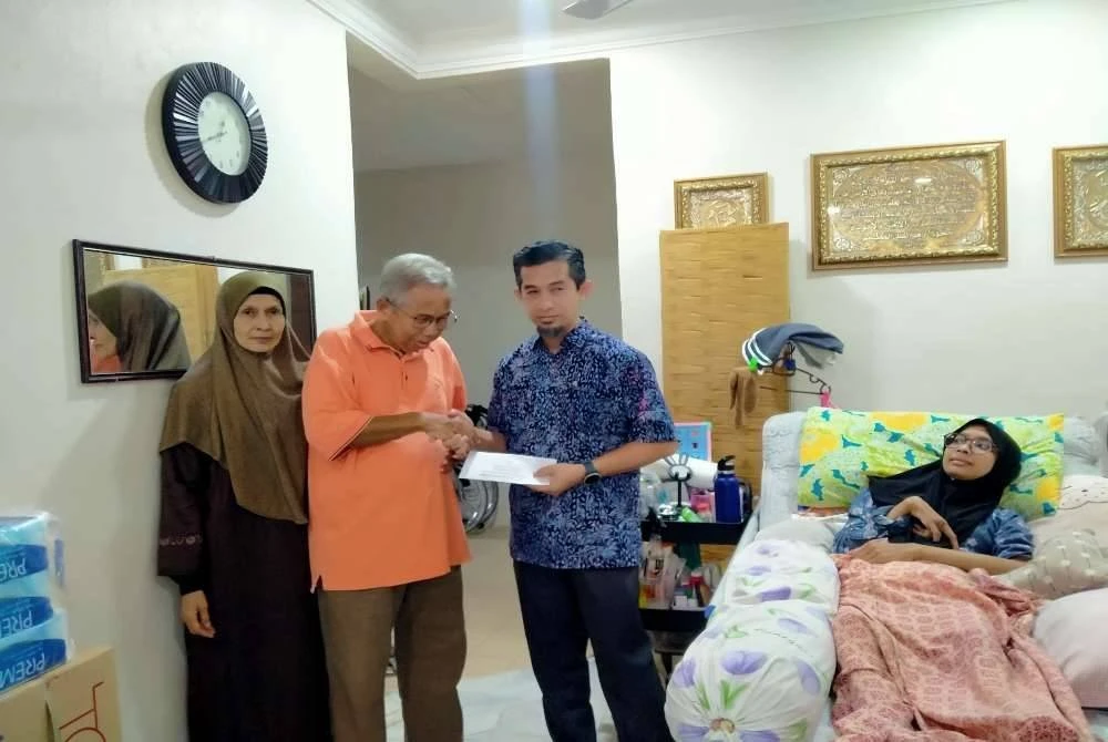 Pengurus Besar Bahagian Agihan Zakat MAIPk, Suhaimi Yusuf (berdiri kanan) menyampaikan sumbangan kepada salah seorang penerima sempena program ZACT 1.0 anjuran ZAPAR di Taman Jati di sini pada Selasa.