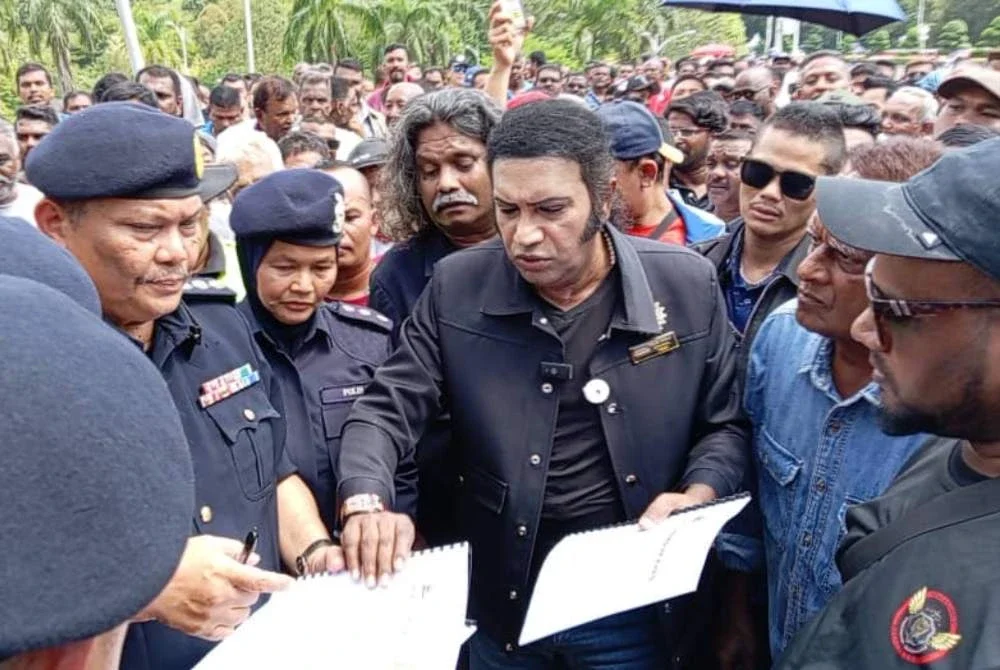 Kalai Vanar (tengah) menyerahkan memorandum di hadapan pintu masuk Parlimen pada Rabu.