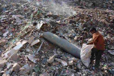 Seorang kanak-kanak lelaki Palestin mengutip plastik berhampiran sebuah peluru yang tidak meletup di kawasan pembuangan sampah di pasar Firas, Bandar Gaza. Foto AFP
