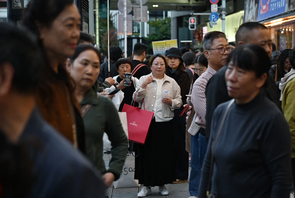 Kumpulan pelancong China menunggu di kawasan membeli-belah Ginza di Tokyo, selepas China menasihati warganya mengelak daripada destinasi pelancongan tersebut susulan kenyataan Perdana Menteri Jepun, Sanae Takaichi mengenai Taiwan. Foto AFP