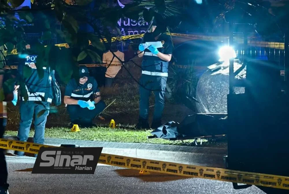Anggota polis menjalankan siasatan di lokasi seorang lelaki maut ditembak di Nusari Biz Sendayan. - Foto: SYAMILAH ZULKIFLI