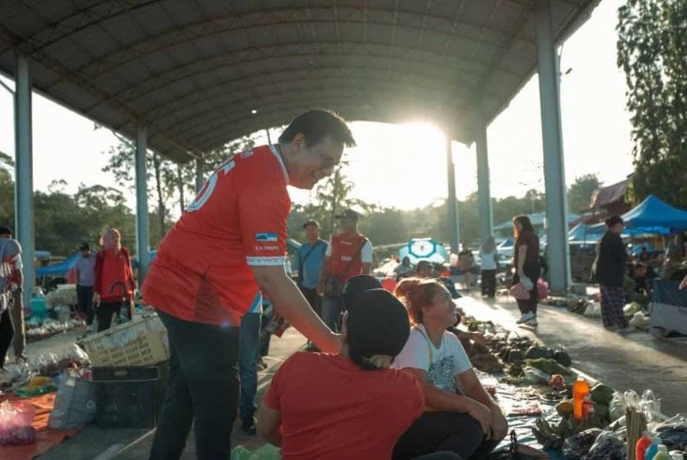 Yamani (kiri) ketika mengadakan sesi walkabout di Pekan Sipitang.