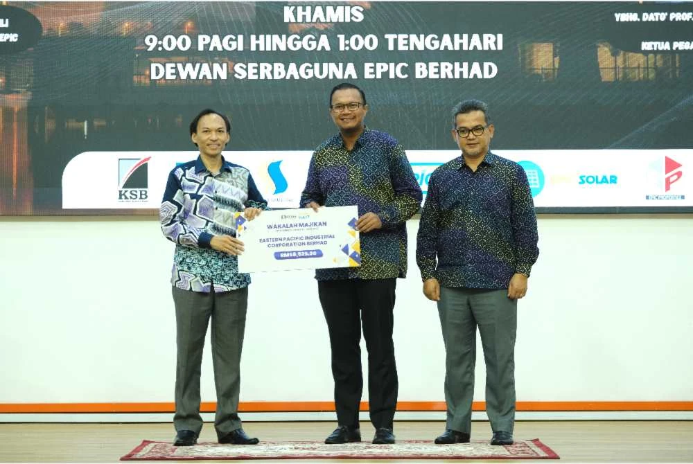 Ahmad Azrin (kiri) menyerahkan cek cura wakalah majikan atau potongan zakat berjadual kepada Muhtar (tengah) pada program agihan zakat kepada 100 asnaf di Dewan Serbaguna EPIC Berhad di Kemaman pada Khamis.