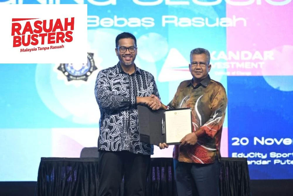  Idzham (kiri) dan Azmi (kanan) selepas menandatangani dokumen ikrar, sebagai simbol tanggungjawab serta akauntabiliti kolektif dalam memperkukuh amalan korporat yang jujur dan telus.