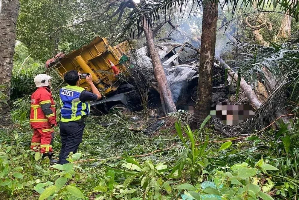 Satu lagi mayat ditemui pada petang Jumaat di bawah lori yang terbabas memasuki gaung sebelum terbakar dalam kejadian di Kilometer 26, Jalan Lok Heng-Mawai, Kota Tinggi pada Khamis. - Foto JBPM Johor 