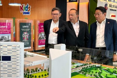 Mahmud (tengah) menunjukkan replika Hotel Grand Mercure Shah Alam kepada Rio (kiri) dan Mohd Najib.