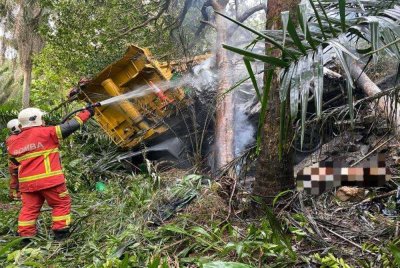 Satu lagi mayat ditemui pada petang Jumaat di bawah lori yang terbabas memasuki gaung sebelum terbakar dalam kejadian di Kilometer 26, Jalan Lok Heng-Mawai, Kota Tinggi pada Khamis. - Foto JBPM Johor 