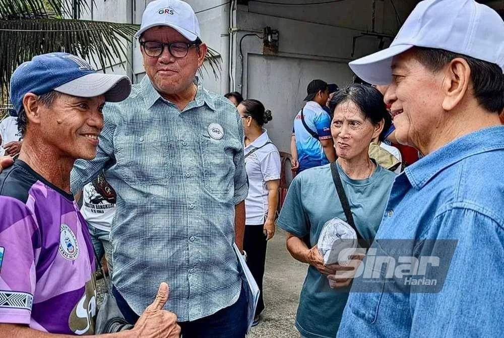 Joniston Bangkuai (dua dari kiri) ditemani Louis Rampas (kanan) menjalankan kempen tinjauan mesra di kawasan Tomis, Kiulu, pada Sabtu.